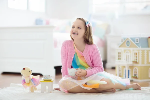 En liten jente som lekte med dukkehuset. Barn med leker – stockfoto