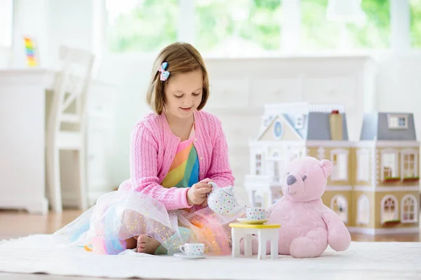 Menina brincando com casa de boneca. Criança com brinquedos — Fotografia de Stock