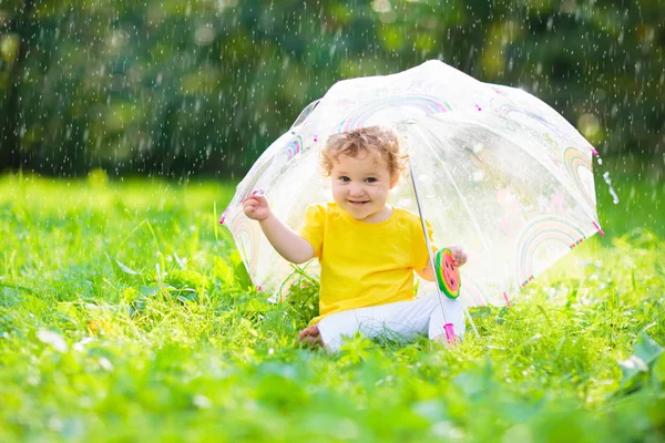 Baby pod parasolem w letnim deszczu. — Zdjęcie stockowe