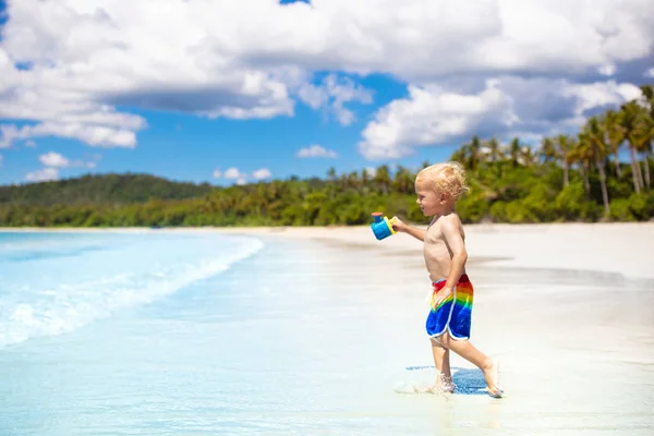 I bambini giocano sulla spiaggia tropicale. Giocattolo di sabbia e acqua . — Foto Stock