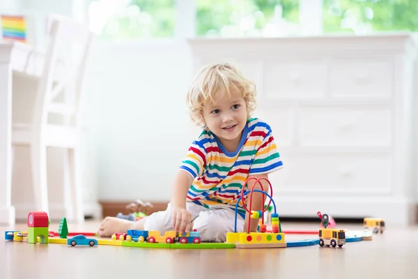 I bambini giocano ferrovia di legno. Bambino con trenino giocattolo . — Foto Stock