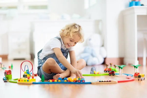 I bambini giocano ferrovia di legno. Bambino con trenino giocattolo . — Foto Stock