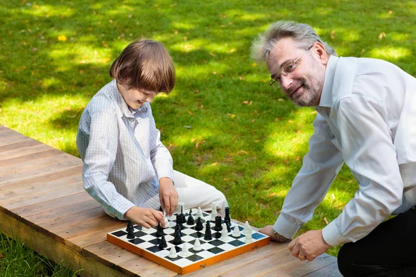 Grandfather, father and kids playing chess. — Stock Photo, Image