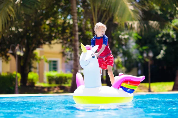 Dítě na jednorožci pluje v bazénu. Děti plavou — Stock fotografie
