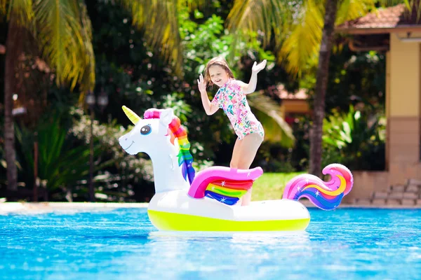 Bambino su unicorno galleggiante in piscina. I bambini nuotano — Foto Stock