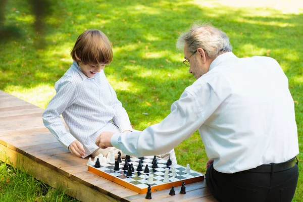 Grandfather, father and kids playing chess. — Stock Photo, Image