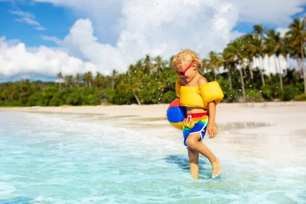 As crianças brincam na praia tropical. Brinquedo de areia e água . — Fotografia de Stock