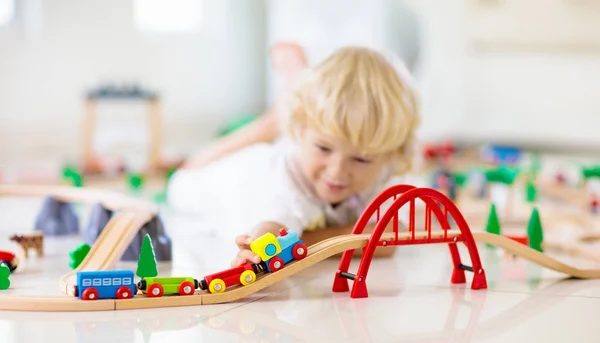 Çocuklar Ahşap demiryolu oynar. Oyuncak tren ile çocuk. — Stok fotoğraf