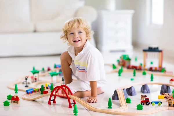 Kinderen spelen houten spoorlijn. Kind met speelgoed trein. — Stockfoto