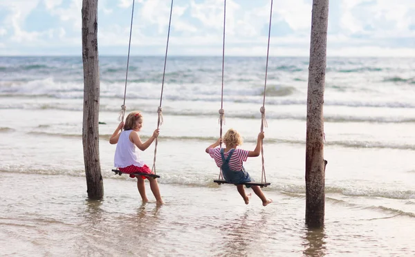 Child on swing. Kid swinging on beach. — Stock Photo, Image