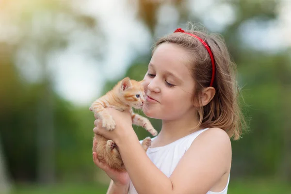 Little girl holding baby cat. Kids and pets — Stock Photo, Image