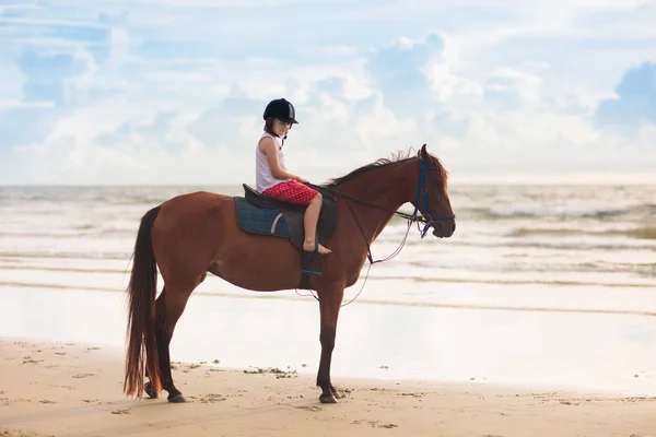 Plajda at sürme çocuklar. Çocuklar atlar binmek. — Stok fotoğraf