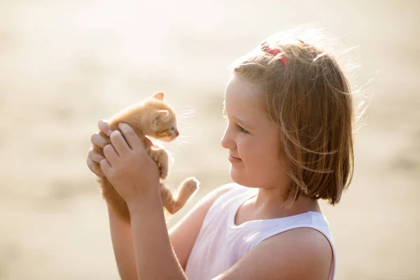赤ちゃん猫を抱いている小さな女の子。子供とペット — ストック写真