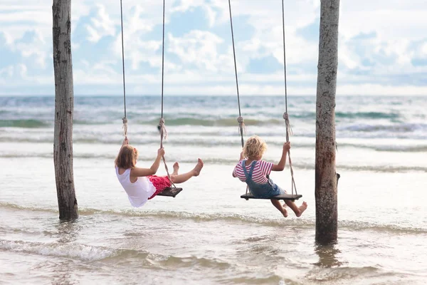 Bambino sull'altalena. Ragazzo che oscilla sulla spiaggia . — Foto Stock