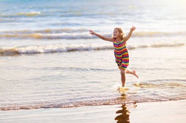 Çocuklar tropik sahilde oynar. Kum ve su oyuncak.
