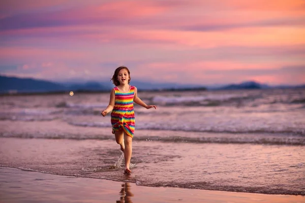 Dziecko gry na plaży oceanu. Dziecko na morzu zachód słońca. — Zdjęcie stockowe