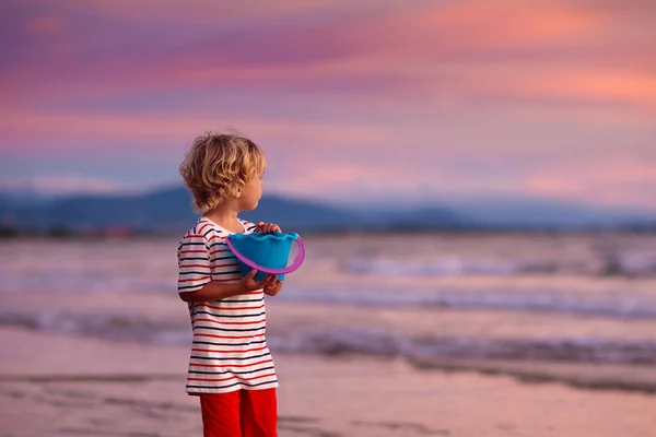 Child playing on ocean beach. Kid at sunset sea. — Stock Photo, Image