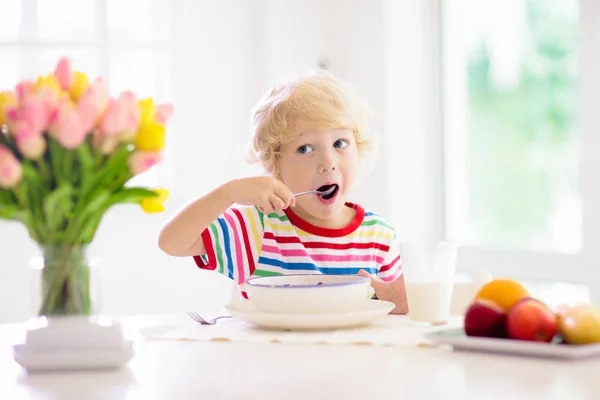 孩子吃早餐。带牛奶和麦片的孩子. — 图库照片