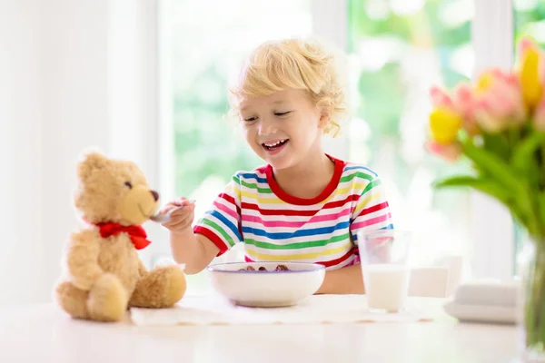 Kind frühstückt. Kind mit Milch und Getreide. — Stockfoto