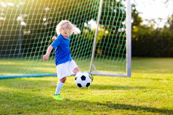 Kids play football. Child at soccer field.