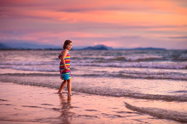 Dziecko gry na plaży oceanu. Dziecko na morzu zachód słońca. — Zdjęcie stockowe