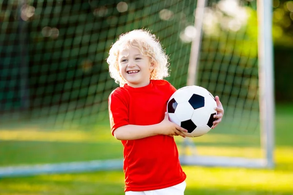 Kinder spielen Fußball. Kind auf Fußballplatz. — Stockfoto