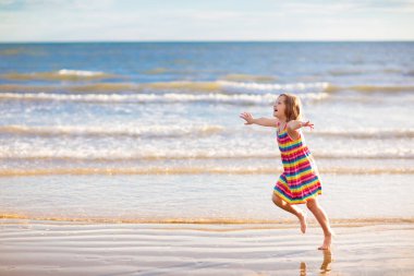 Çocuklar tropik sahilde oynar. Kum ve su oyuncak.