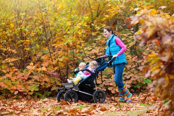 Caminhadas em família com carrinho no parque de outono — Fotografia de Stock