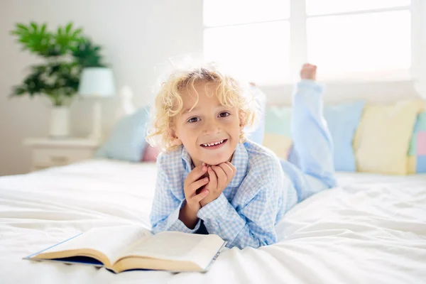 Bambino che legge libro a letto. Bambini letti in camera da letto. — Foto Stock