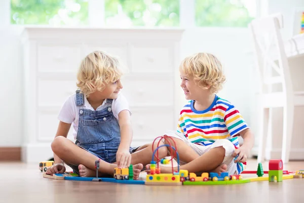 I bambini giocano ferrovia di legno. Bambino con trenino giocattolo . — Foto Stock