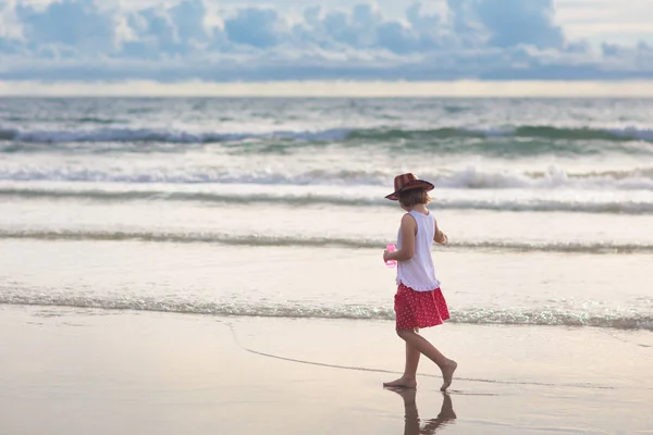 Dzieci grają na tropikalnej plaży. Zabawki do piasku i wody. — Zdjęcie stockowe