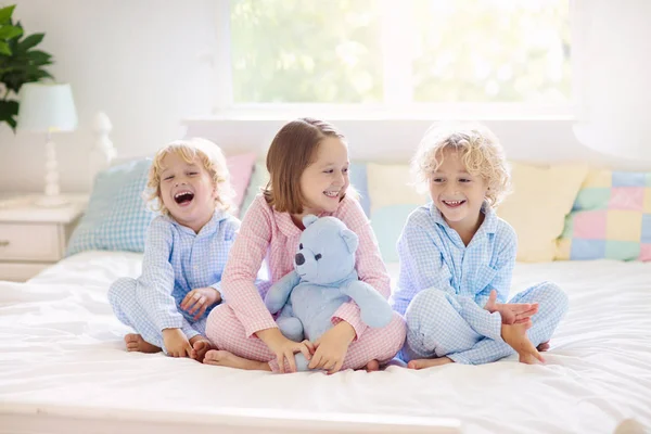 Barnen leker i sängen. Barn hemma. — Stockfoto