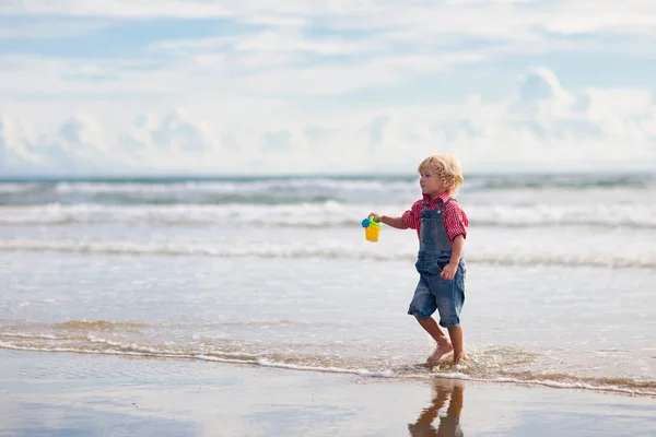 Çocuklar tropik sahilde oynar. Kum ve su oyuncak. — Stok fotoğraf