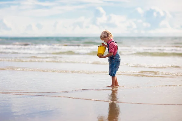 As crianças brincam na praia tropical. Brinquedo de areia e água . — Fotografia de Stock