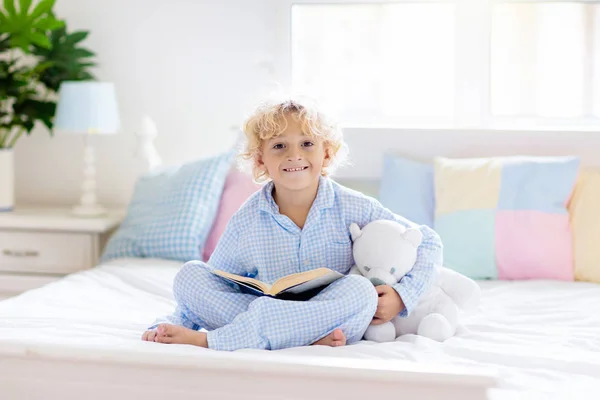 Livro de leitura infantil na cama. Crianças lêem no quarto. — Fotografia de Stock