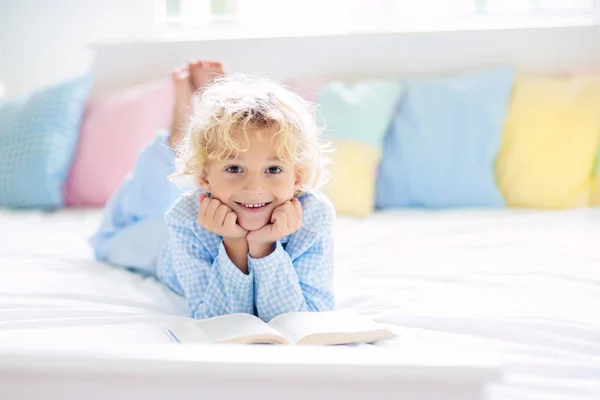 Child reading book in bed. Kids read in bedroom. — Stock Photo, Image