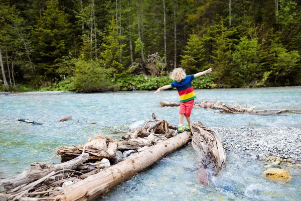 Dítě, turistiku v horách. Děti na břehu řeky. — Stock fotografie