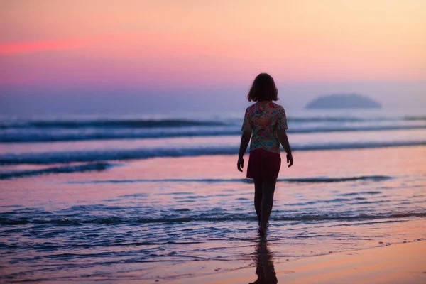 Dziecko gry na plaży oceanu. Dziecko na morzu zachód słońca. — Zdjęcie stockowe