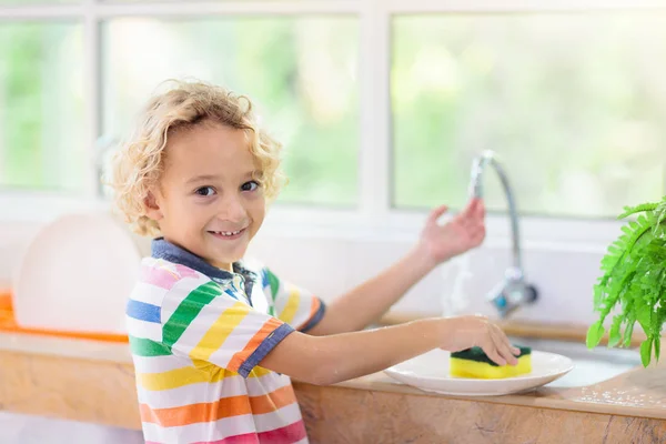 Child washing dishes.
