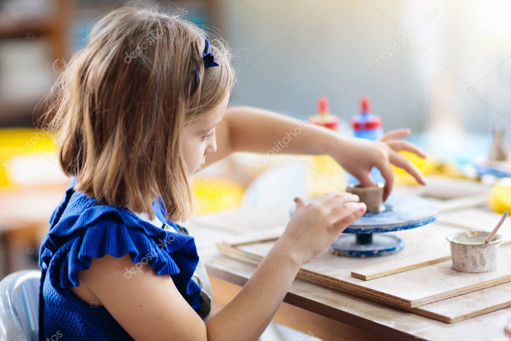 Child at pottery wheel. Kids arts and crafts class