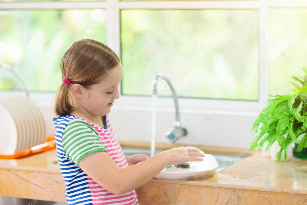 Child washing dishes. 