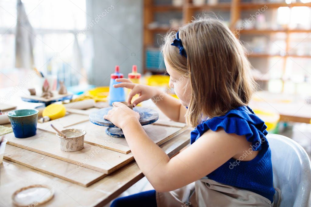 Child at pottery wheel. Kids arts and crafts class