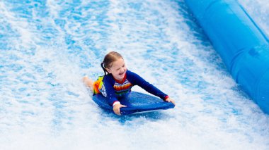 Küçük kız plaj dalga simülatörü sörf