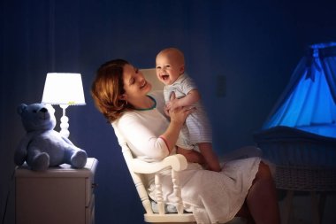 Anne ve bebek karanlık yatak odasında