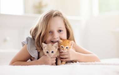 Küçük çocuk bebek kedi tutuyor. Çocuklar ve evcil hayvanlar