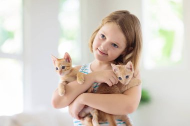 Küçük çocuk bebek kedi tutuyor. Çocuklar ve evcil hayvanlar