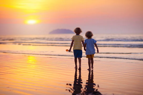 孩子们在海边玩耍。孩子在日落海. — 图库照片