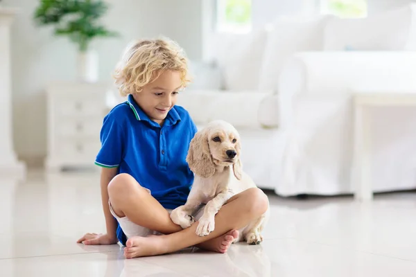 Kind spielt mit Hund. Kinder spielen mit Welpen. — Stockfoto