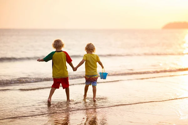 海のビーチで遊ぶ子。サンセットの海を子供します。. — ストック写真