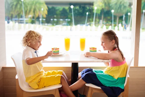 Los niños comen pastel en el restaurante. Niño y niña en la cafetería . — Foto de Stock